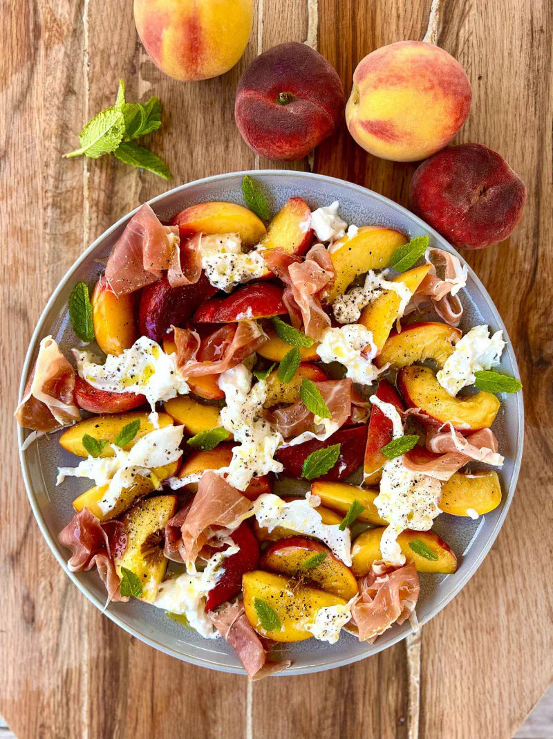 Salade van perzik en burrata met parmaham en munt